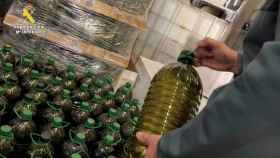 Los agentes de la Guardia Civil, inspeccionando botellas de aceite de oliva fraudulento.