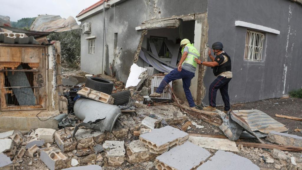 Los trabajadores humanitarios caminan sobre los daños causados por Israel en la aldea de Dhayra de Líbano.