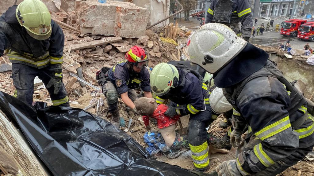 Los equipos de rescate sacan de los escombros el cuerpo de un niño tras la caída de un misil ruso en Járkov (Ucrania).