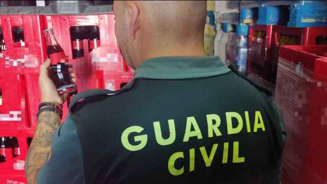 Agente de la Guardia Civil con parte de los refrescos incautados