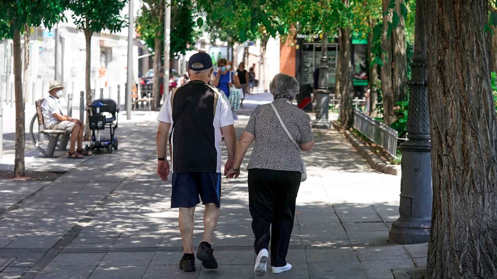 Una pareja de ancianos camina por la calle cogida de la mano