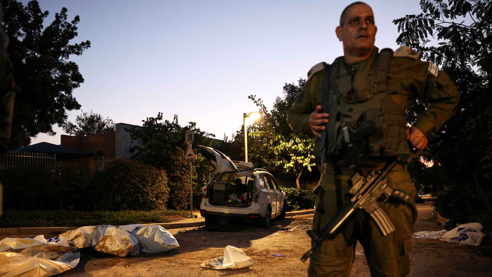 Un militar israelí custodia los cuerpos de algunos de los asesinados por Hamás en el kibutz Beeri.