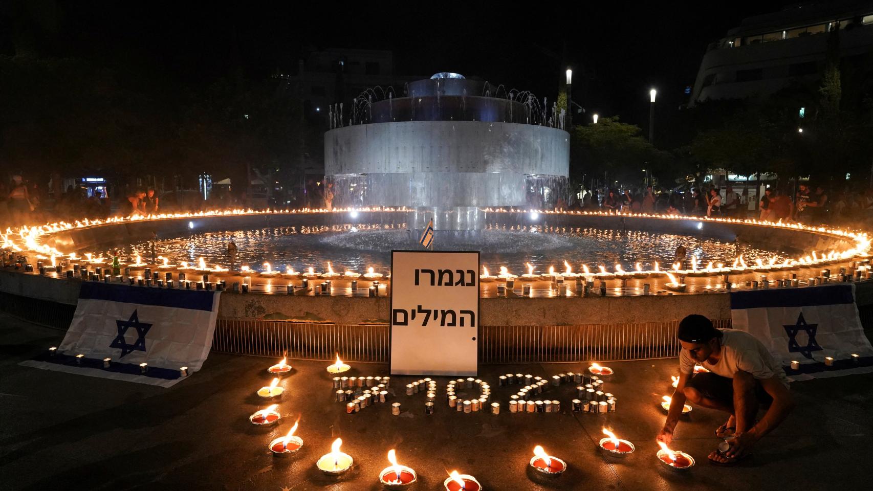 Un grupo de personas enciende velas en la plaza Dizengoff, en Tel Aviv.