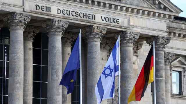 Una bandera israelí ondea junto a una bandera alemana y una de la UE ante el Reichstag.