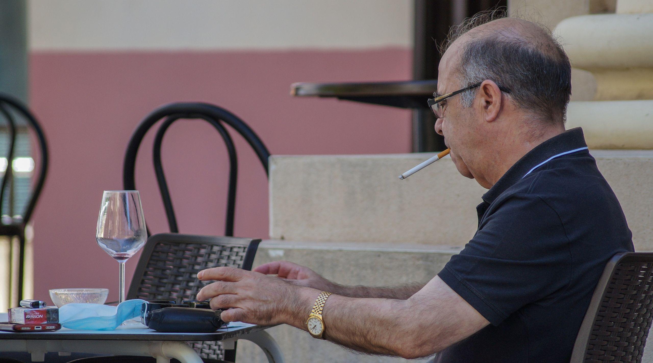 Hombre fuma en la terraza de un bar durante la pandemia