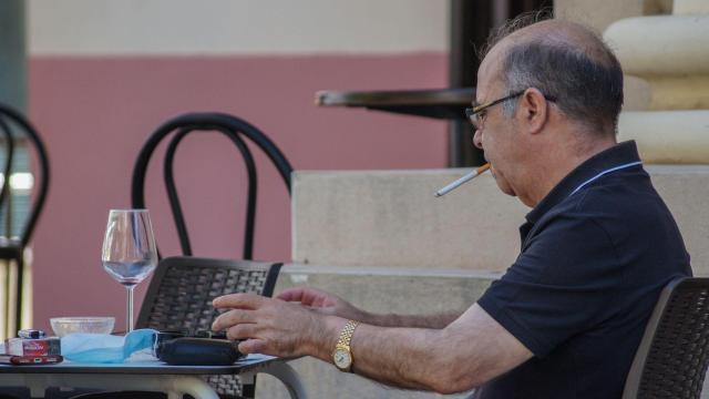 Hombre fuma en la terraza de un bar durante la pandemia