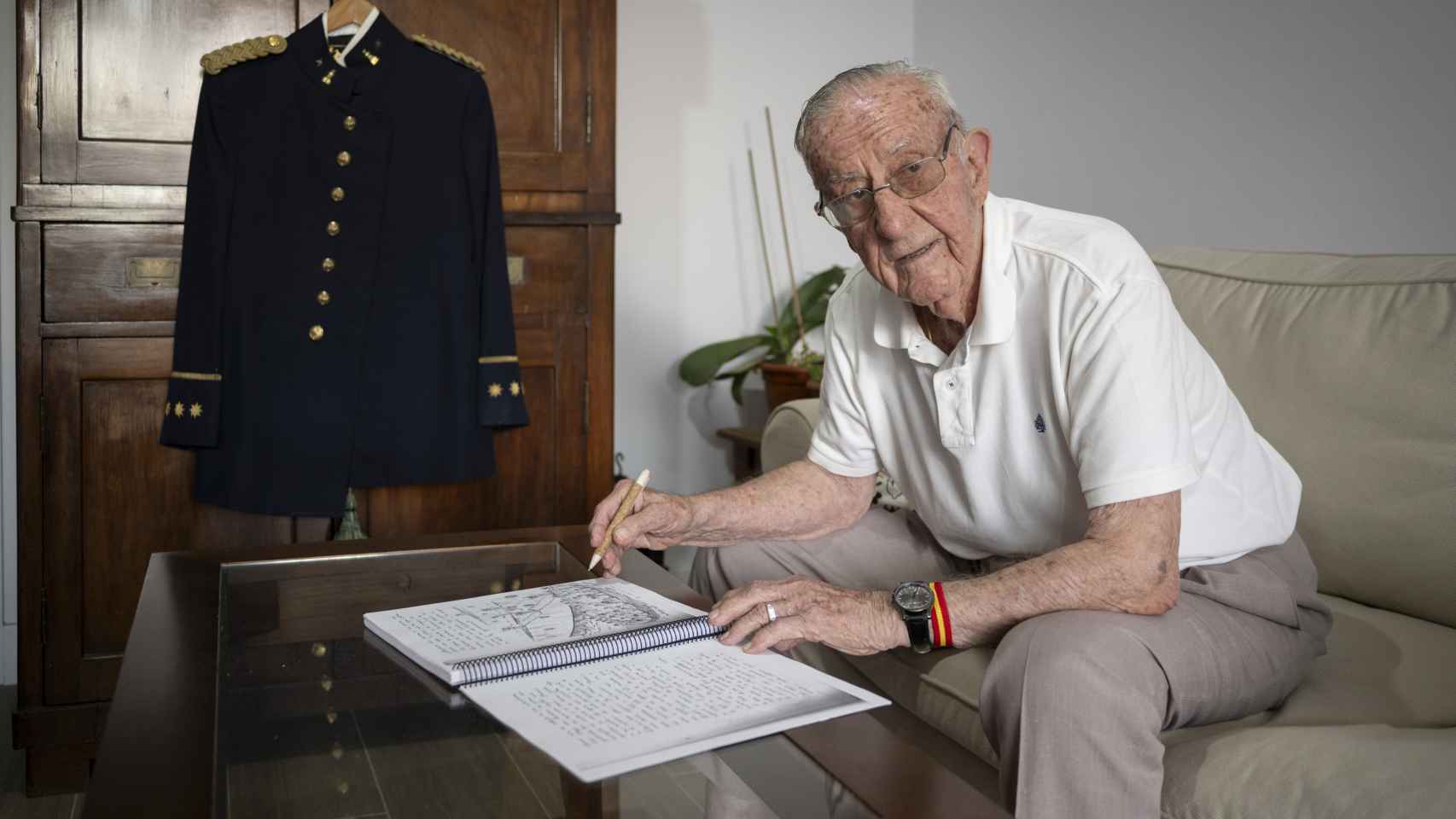 José Sevillano dibujando en un cuaderno , junto a su uniforme de gala en un antiguo armario familiar.