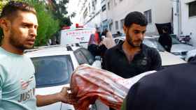 Un hombre sostiene el cuerpo de un niño víctimas de los bombardeos israelíes en la ciudad de Gaza .