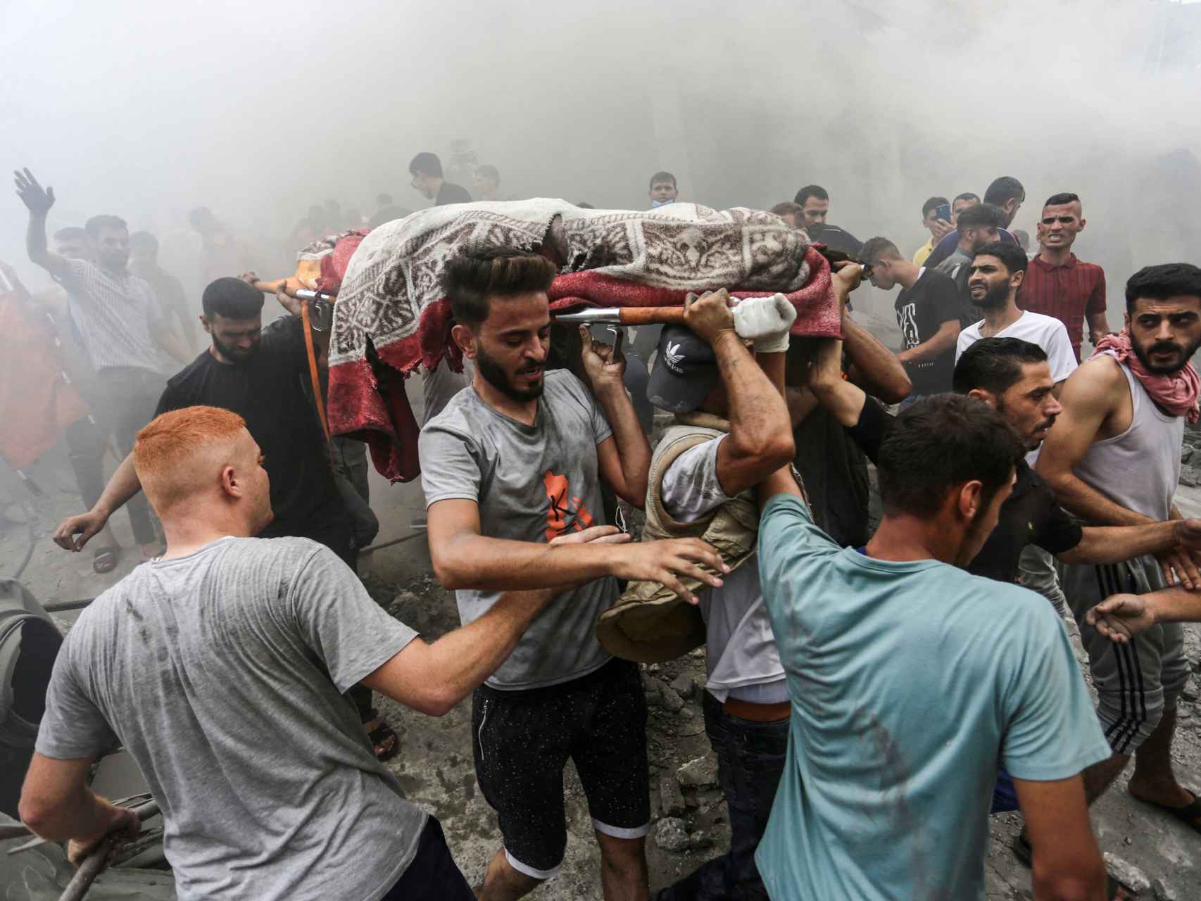 Gazatíes transportan el cadáver de una víctima de un bombardeo de Israel.