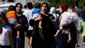 Tres mujeres caminan con sus hijos a un refugio de la ONU en el sur de Gaza, este viernes.