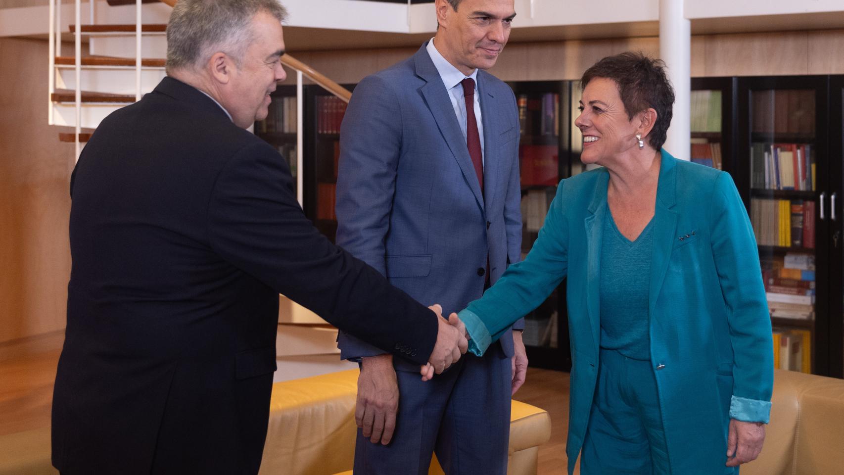 Mertxe Aizpurua saluda a Santos Cerdán, secretario de Organización del PSOE, en presencia del presidente del Gobierno, Pedro Sánchez, en el Congreso de los Diputados, este viernes.