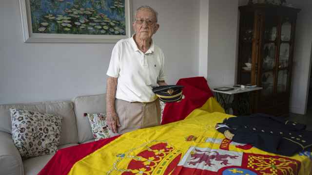 José Sevillano, posando con el uniforme de gala de Coronel del Cuerpo de Ingenieros y una bandera de España.