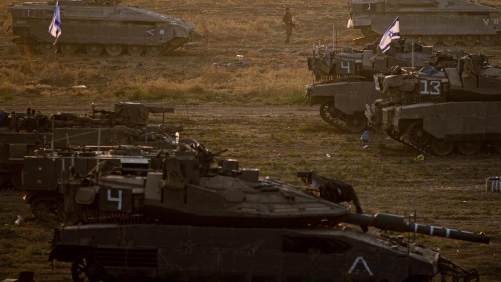 Un soldado israelí camina junto a varios tanques en los alrededores de la Franja de Gaza, en el sur de Israel.