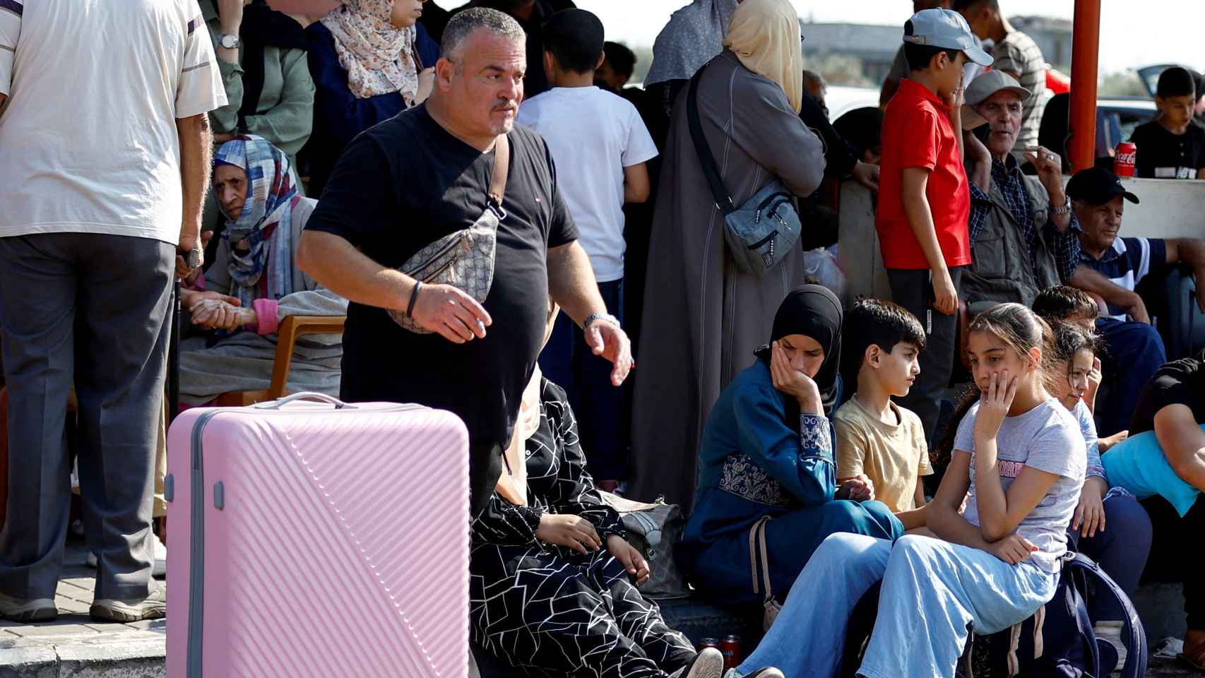 Refugiados palestinos esperan en la frontera de Rafah con el paso fronterizo cerrado