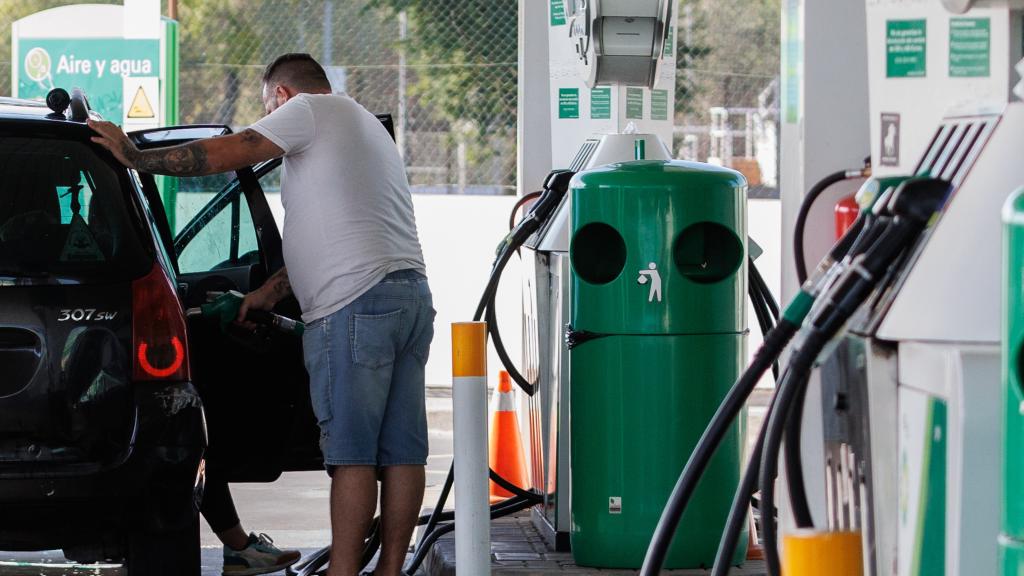 Un hombre llenando el depósito de su coche.