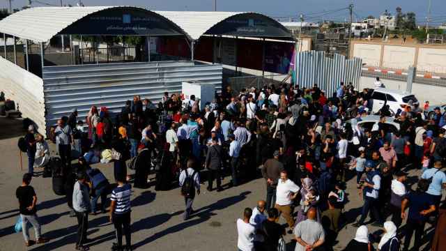 Palestinos con doble ciudadanía se reúnen frente al cruce fronterizo de Rafah con Egipto.