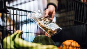 Imagen de una mujer comprando frutos secos en el supermercado.