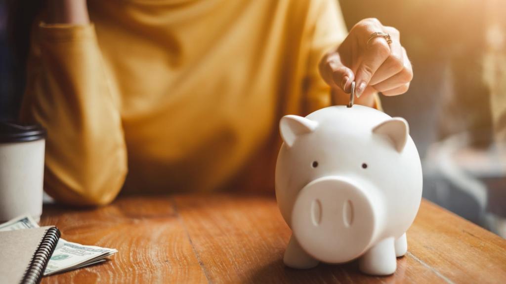 Mujer con una hucha introduciendo dinero.