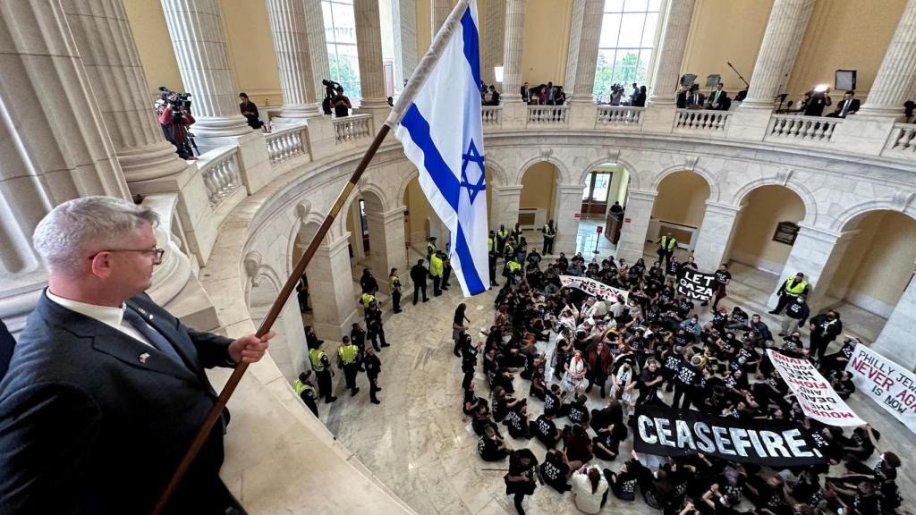 El senador republicano Brandon Williams ondea una bandera israelí durante la protesta.