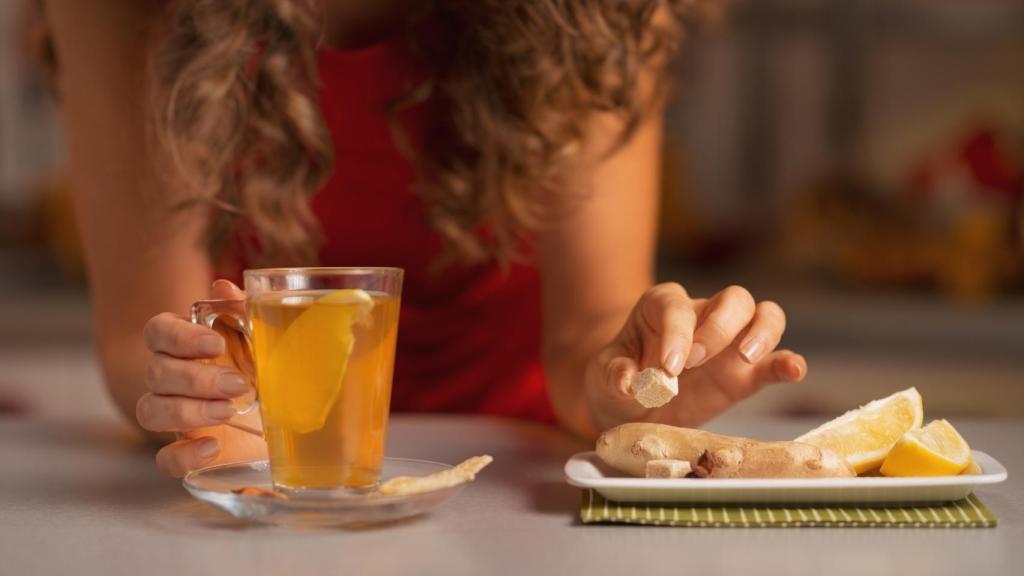 Mujer sujetando una taza con té de jengibre.