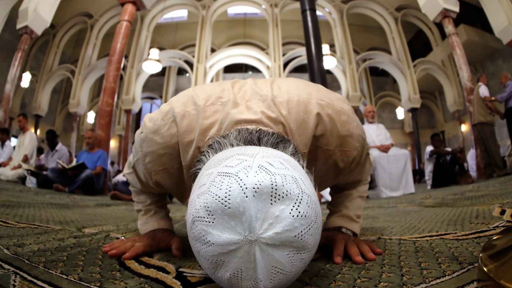 Un grupo de musulmanes rezando en una mezquita.