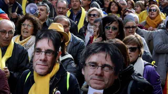 Independentistas se manifiestan en Barcelona con caretas de Carles Puigdemont.