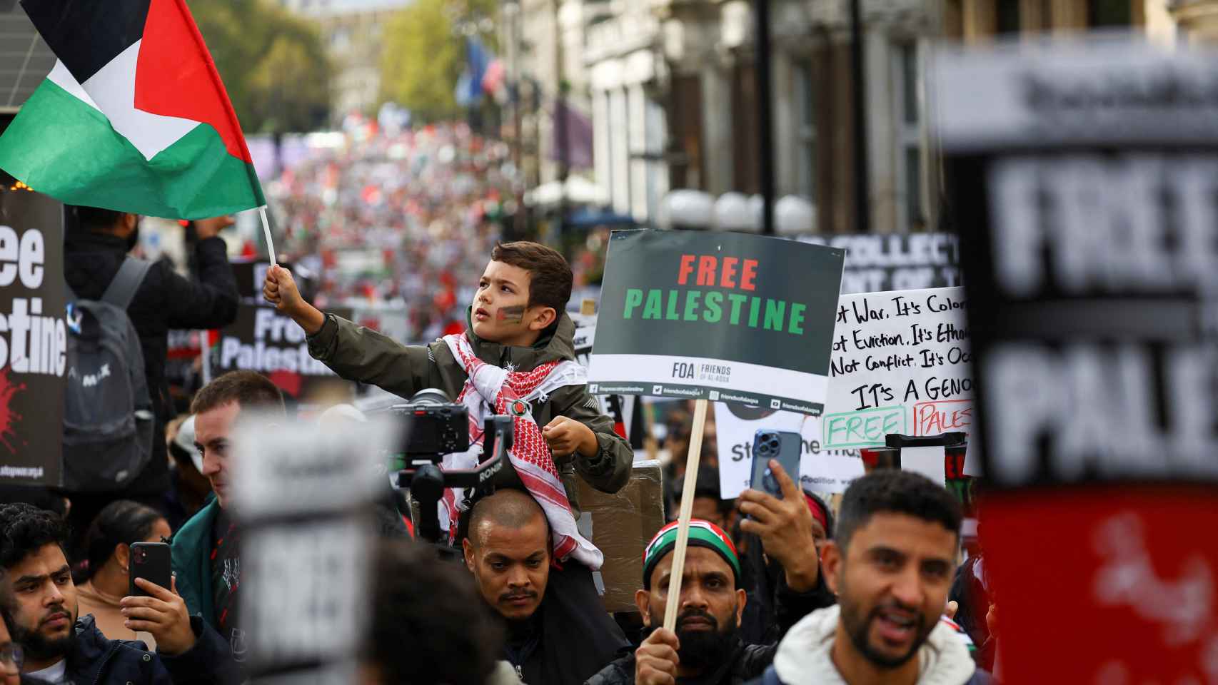 Un niño porta una bandera palestina en la manifestación de Londres