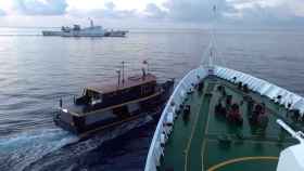 Un buque de la Guardia Costera china bloquea una barca filipina, en un fotograma publicado este domingo.