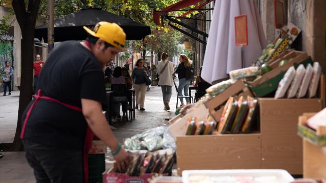 Un dependiente coloca fruta en un comercio de Barcelona.