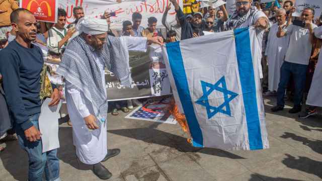 Un partidario de Hamás quema una bandera israelí en Salé, Marruecos.