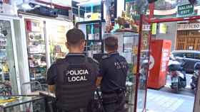 Los agentes de la Policía Local de Alicante, controlando una tienda de compraventa.