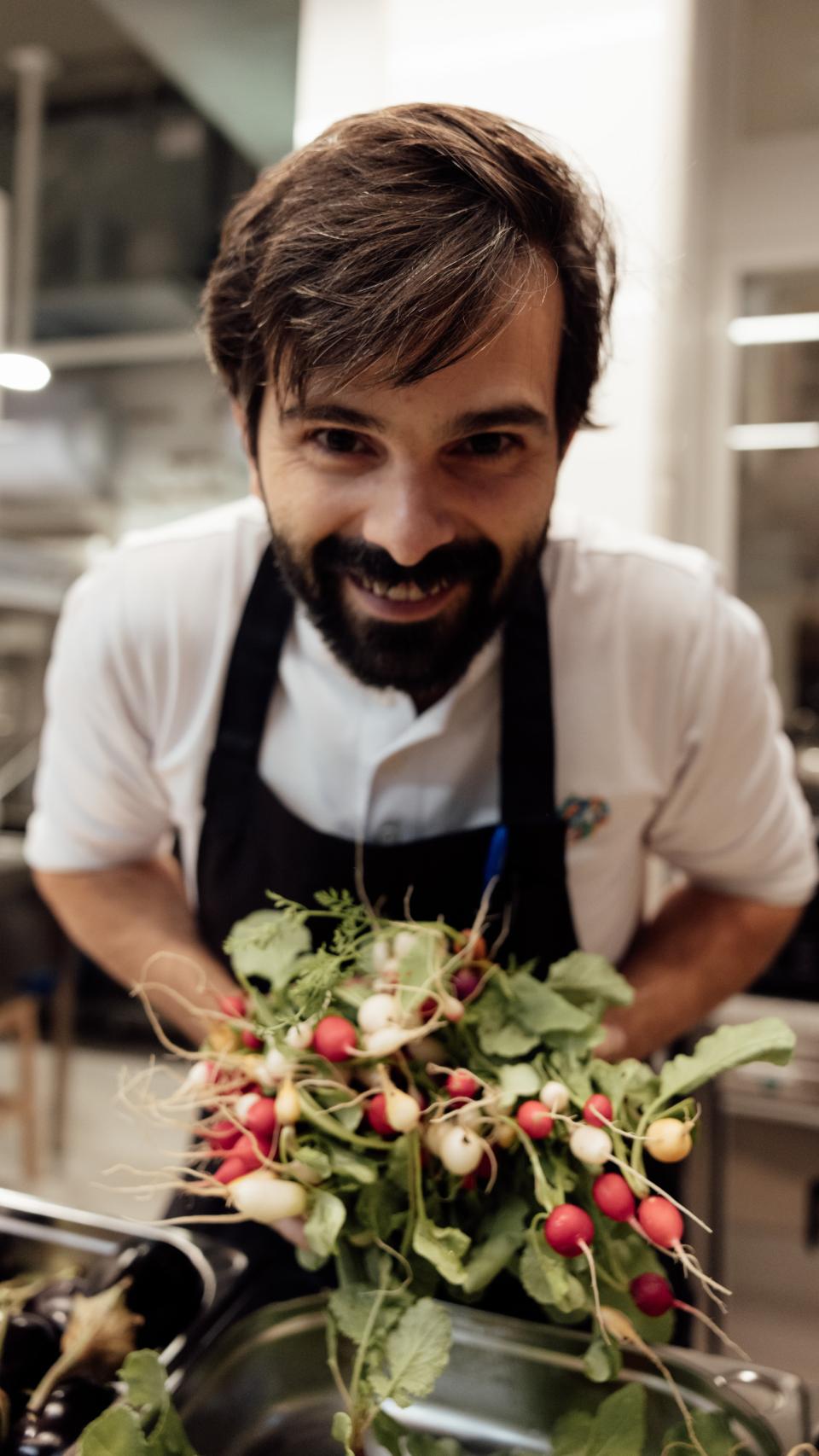 El chef Coco Montes en la cocina con rábanos, uno de los productos de microtemporada este otoño.