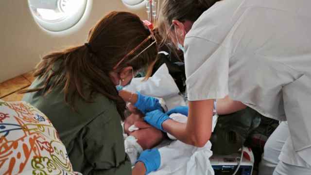 Especialistas de la UMAER y del Hospital maternoinfantil Sant Joan de Déu atienden a las dos niñas siamesas durante la aeroevacuación.