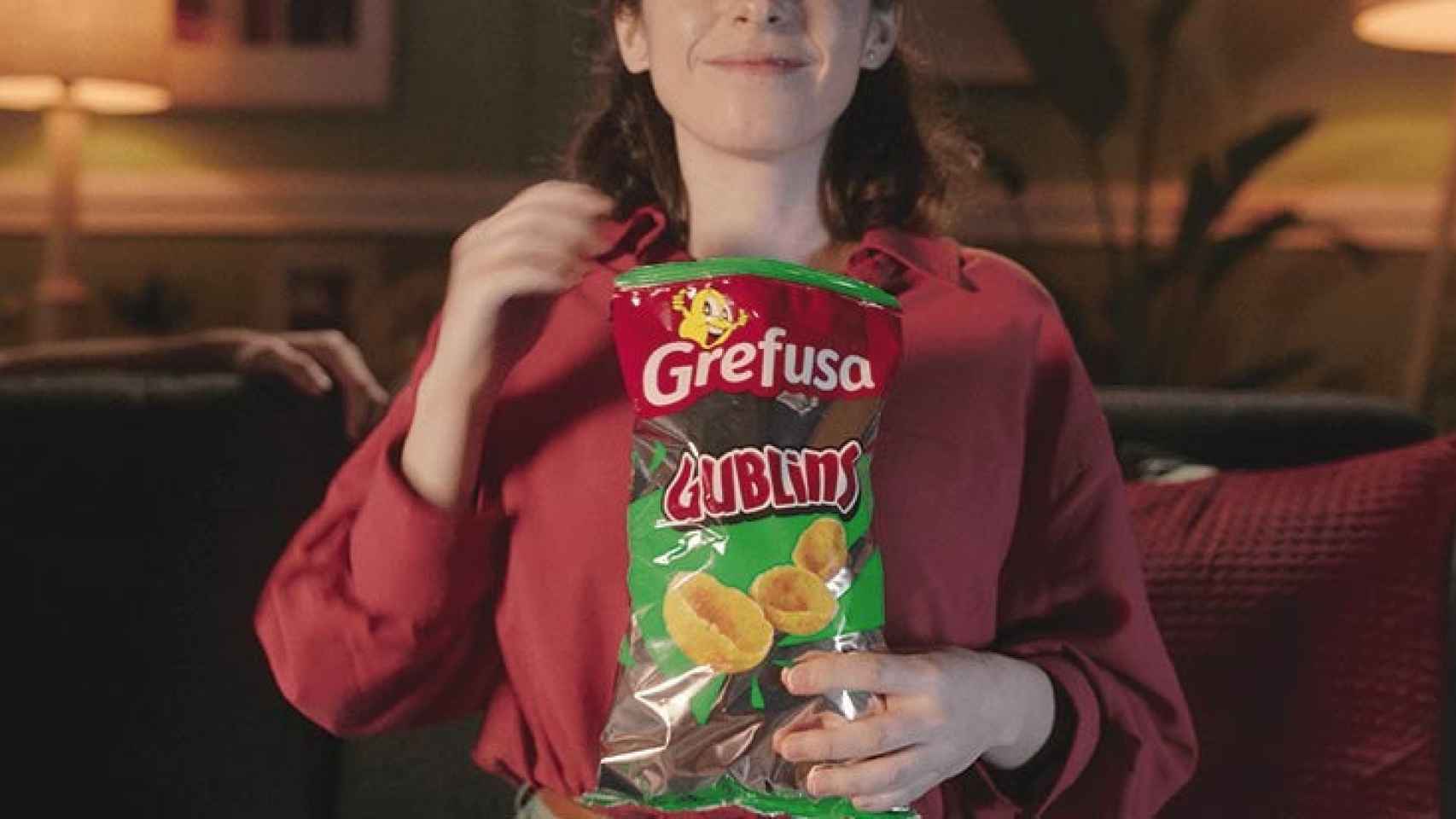 Imagen de archivo de una mujer comiendo snacks de Grefusa.
