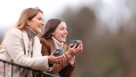 Imagen de dos amigas tomando un café al aire libre.