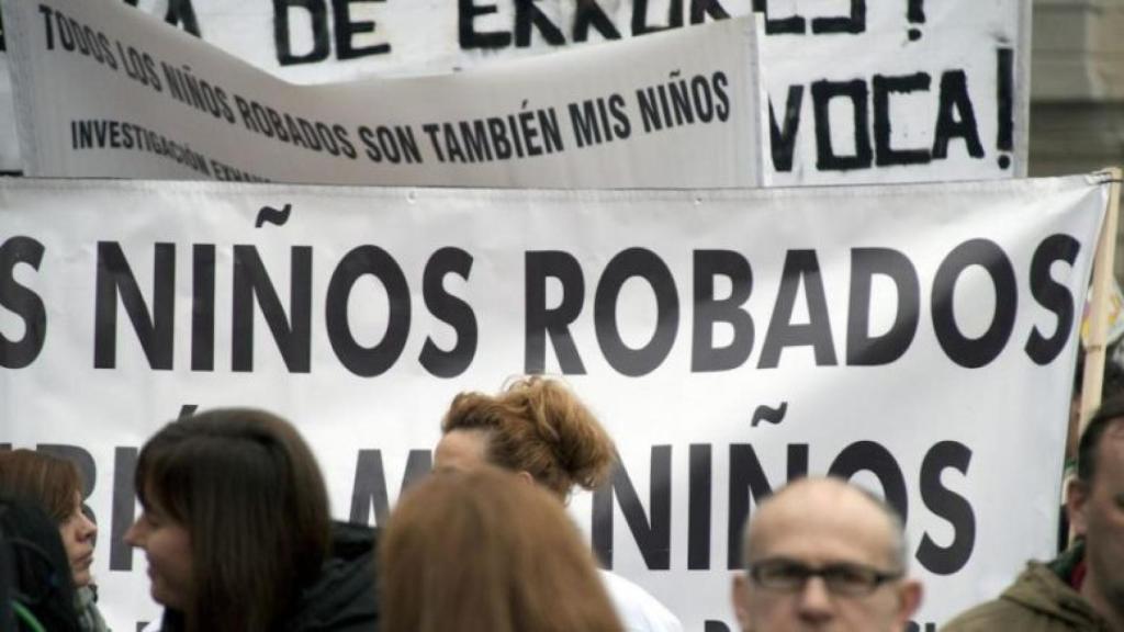 Varias personas sostienen pancartas durante una manifestación contra los bebés robados.