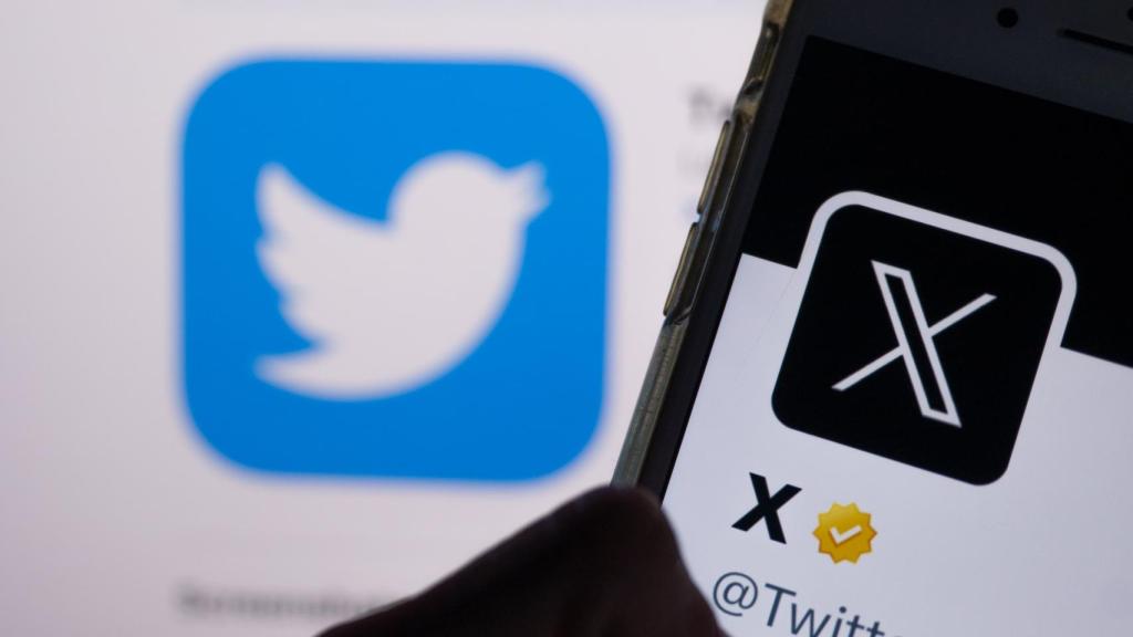 Imagen de una cuenta de X en un teléfono móvil delante del logo de Twitter.