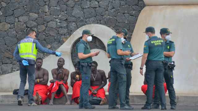 Guardias civiles atienden a varios migrantes subsaharianos llegados a la isla de El Hierro, en Canarias.
