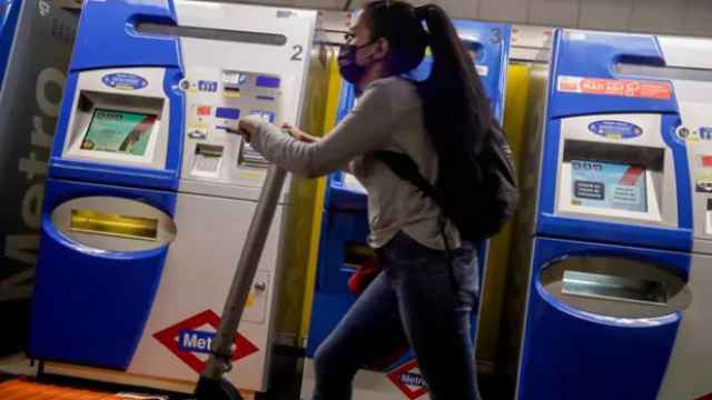 Una chica con un patinete en el Metro de Madrid.