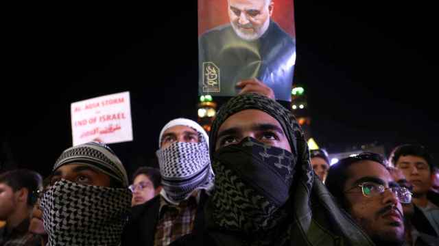 Un grupo de iraníes sostienen el retrato de Soleimani y claman la destrucción de Israel.