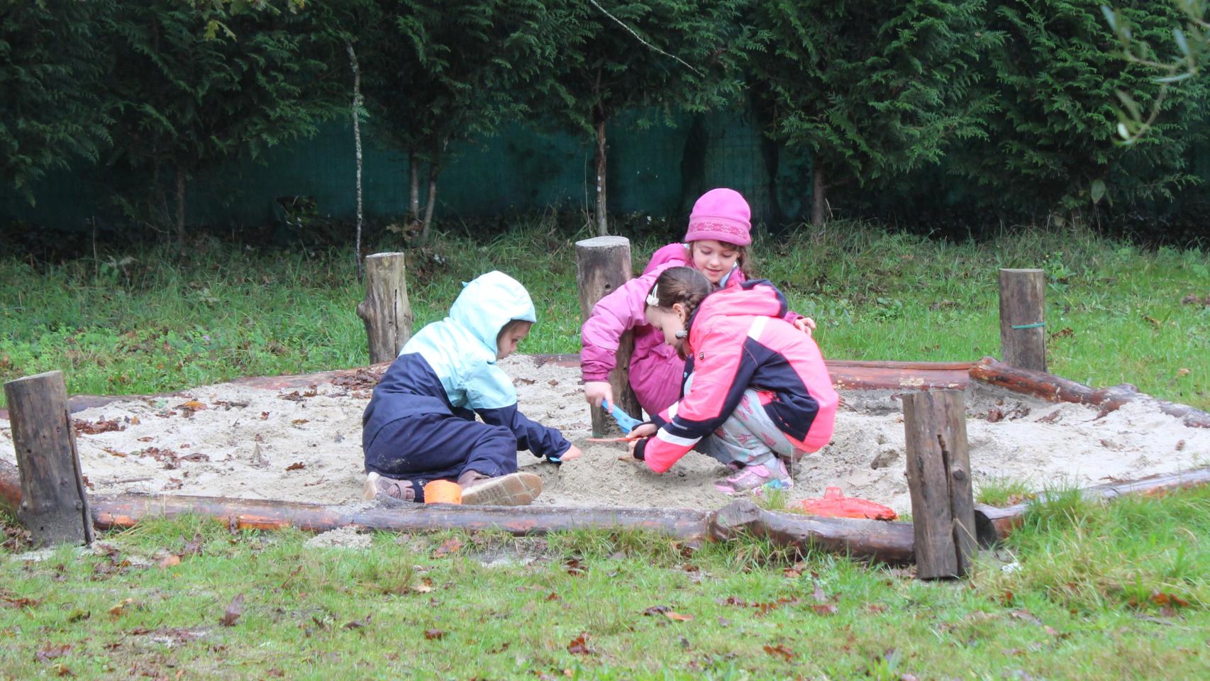 Niños juegan en el arenero de la escuela.