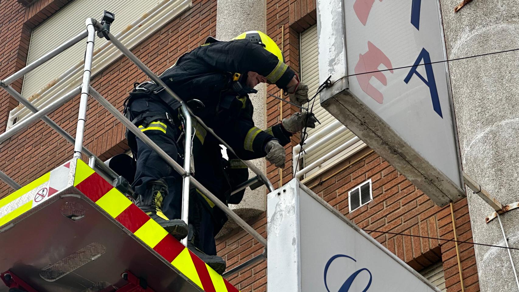 Los bomberos del Ayuntamiento de León fijando un cable que estaba suelto