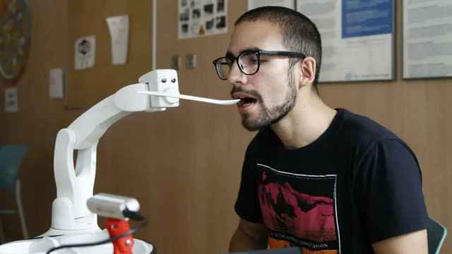 Un robot asistencia ayudando a comer a una persona con movilidad reducida.