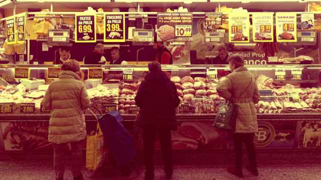Varias mujeres compran en una carnicería en un mercado en Madrid.