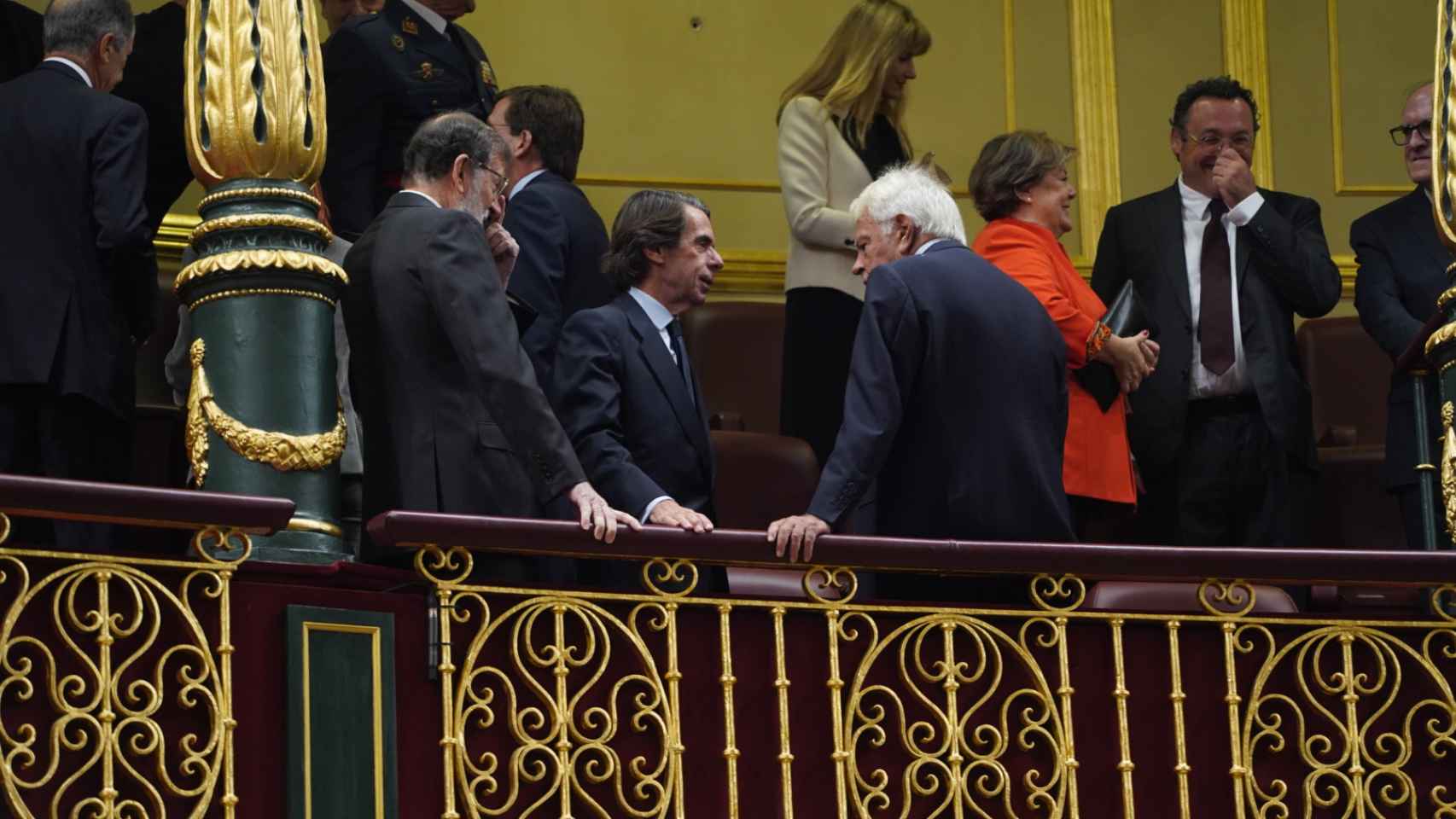 Los expresidentes populares, José María Aznar y Mariano Rajoy, departen con el socialista Felipe González, en la tribuna del Congreso.