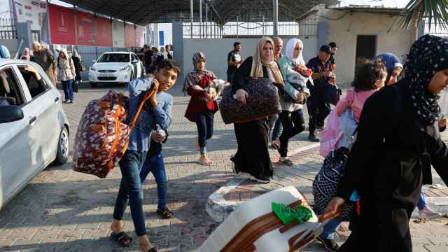 Varios palestinos abandonando la Franja de Gaza por el paso de Rafah este jueves.