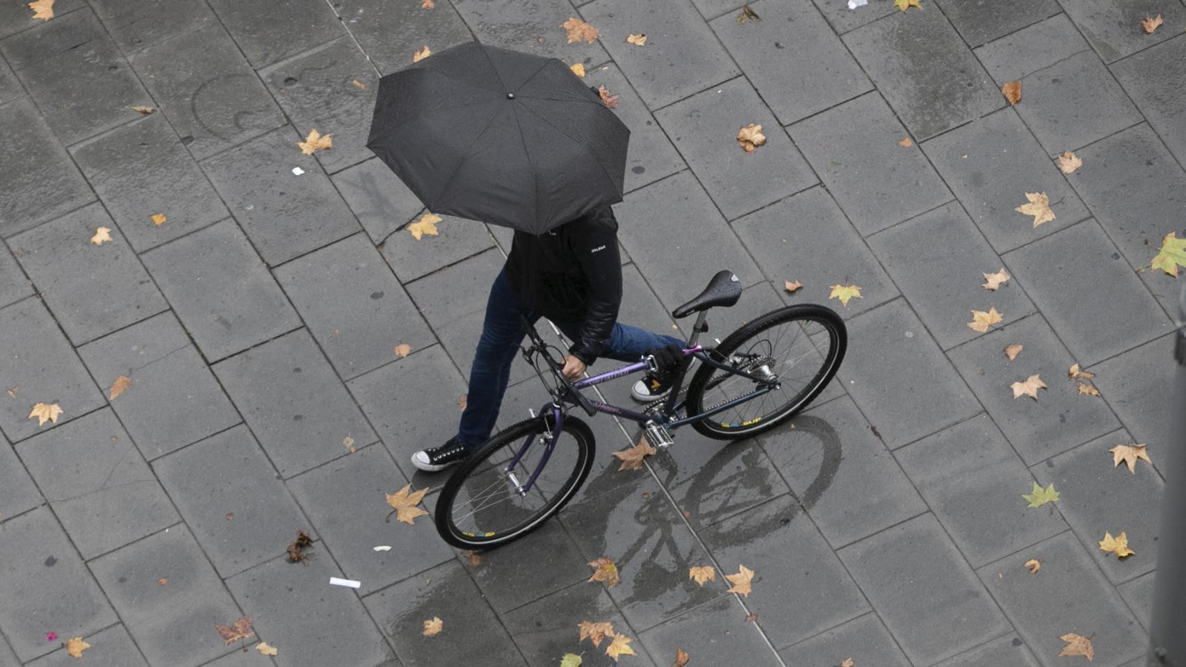 Un viandante se protege de la lluvia este jueves en Zaragoza durante el paso de 'Ciarán', una borrasca de alto impacto procedente del Reino Unido.