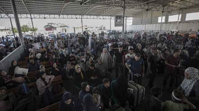 Cientos de ciudadanos palestinos esperando a abandonar Gaza en el paso de Rafah