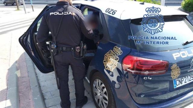 Un agente en un coche de la Policía Nacional