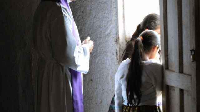 Un párroco observa desde atrás a unas niñas